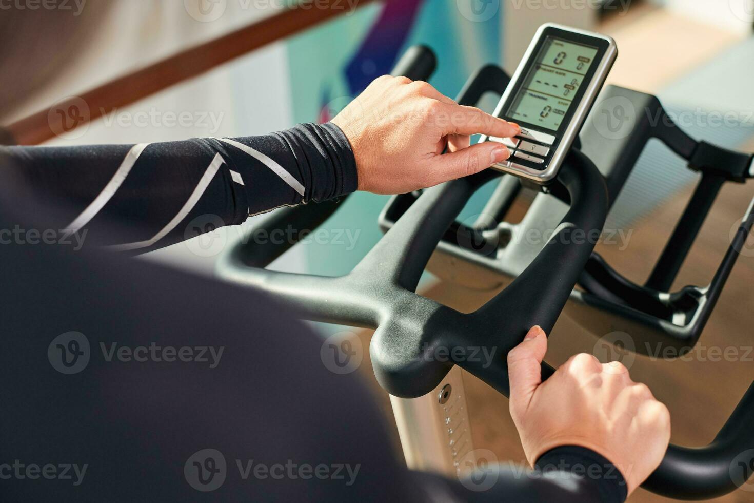 Woman hands on a bar stationary bike the gym photo
