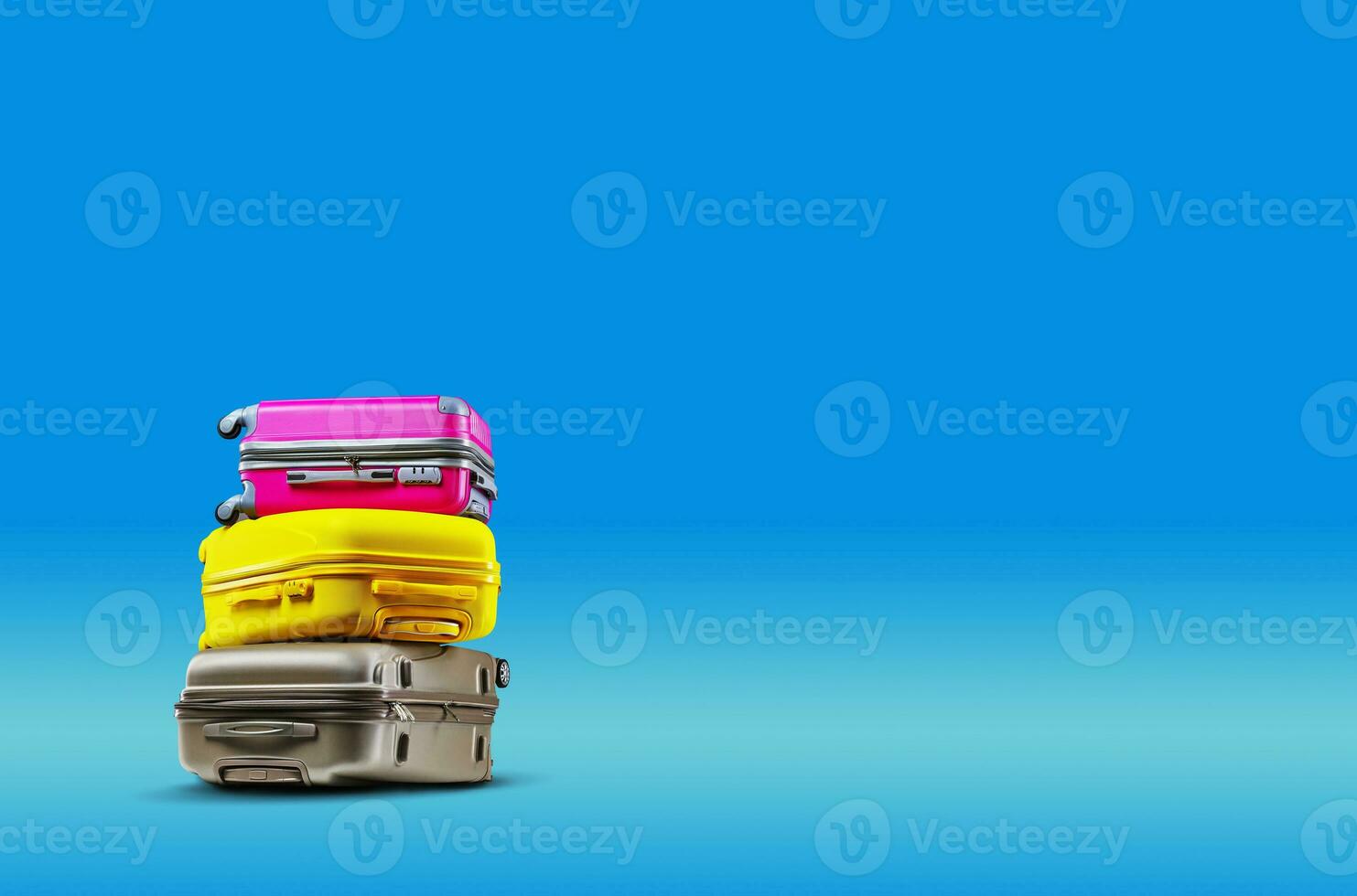 Three multicolored suitcases are lying on top of each other against a blue background. Collage. Copy space, close-up. photo