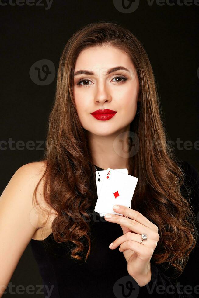 Sexy curly hair brunette posing with two aces cards in her hands, poker concept isolation on white background photo