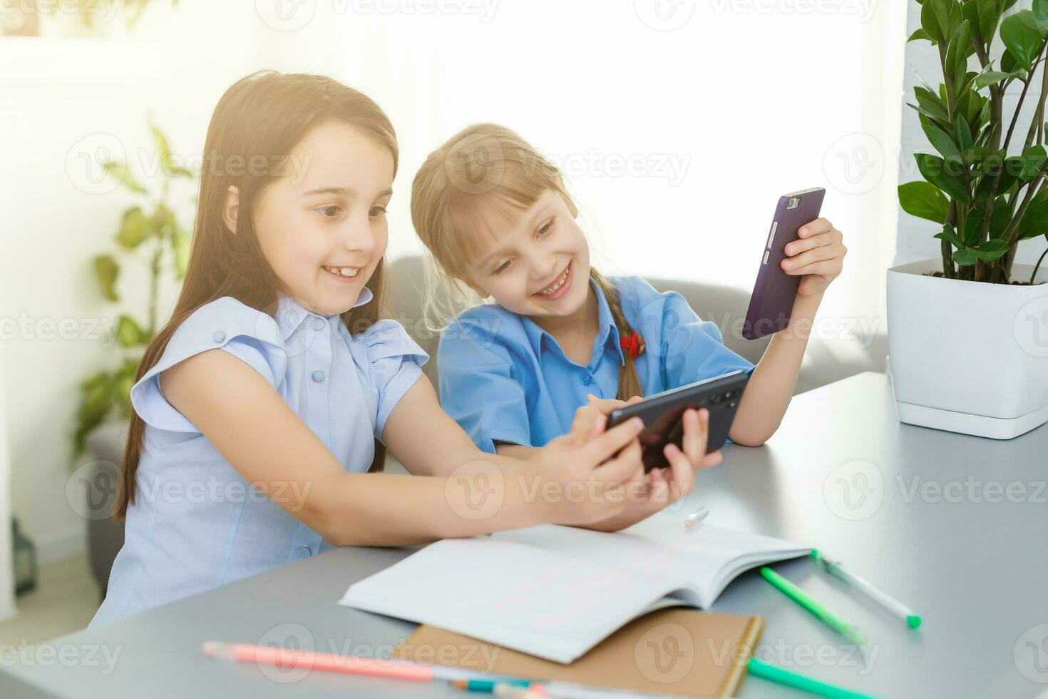 bonito elegante colegialas estudiando durante su en línea lección a hogar, social distancia durante cuarentena, autoaislamiento, en línea educación concepto foto