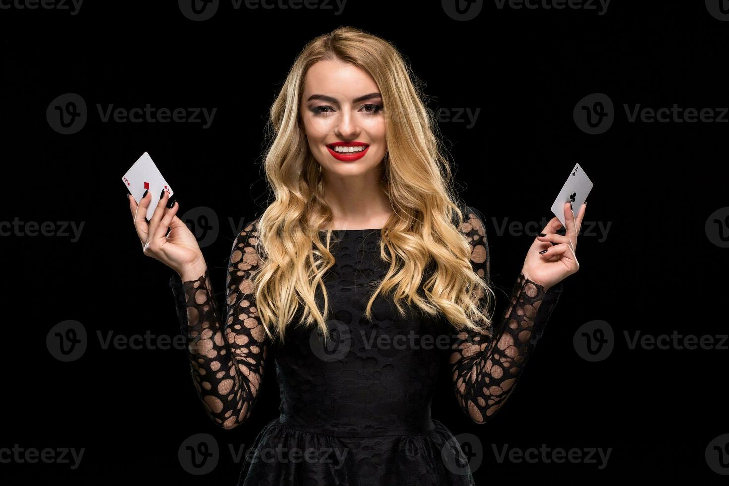 Beautiful young woman holding two ace of cards in her hand isolated on black background photo