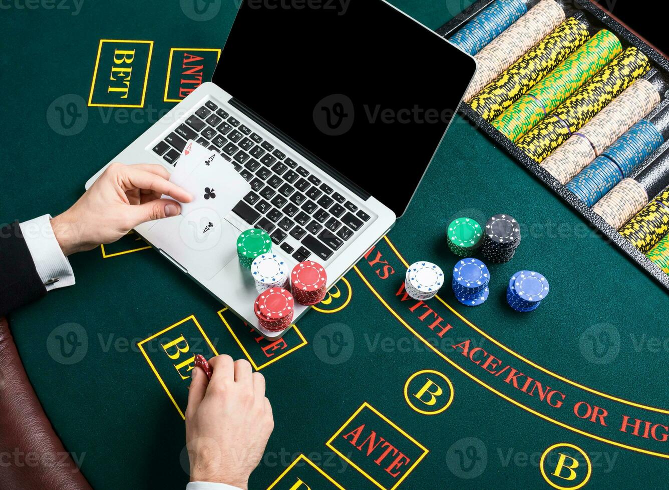casino, online gambling, technology and people concept - close up of poker player with playing cards photo