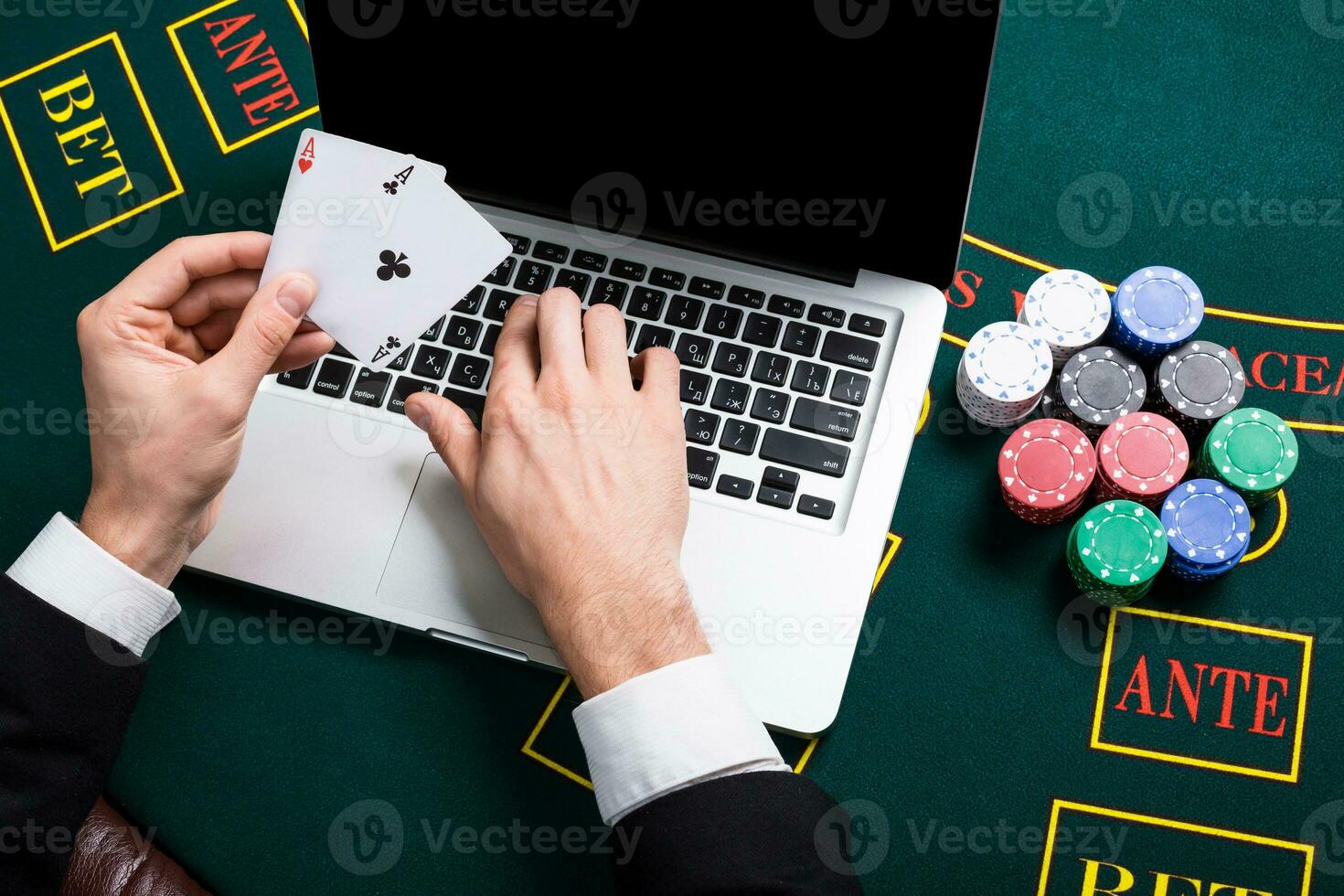 casino, online gambling, technology and people concept - close up of poker player with playing cards photo