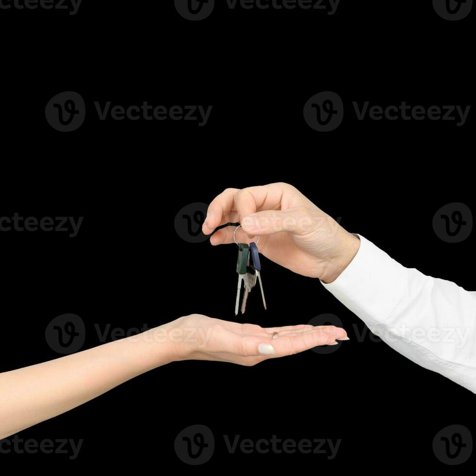 A man hands the keys to a girl isolated on white studio background photo