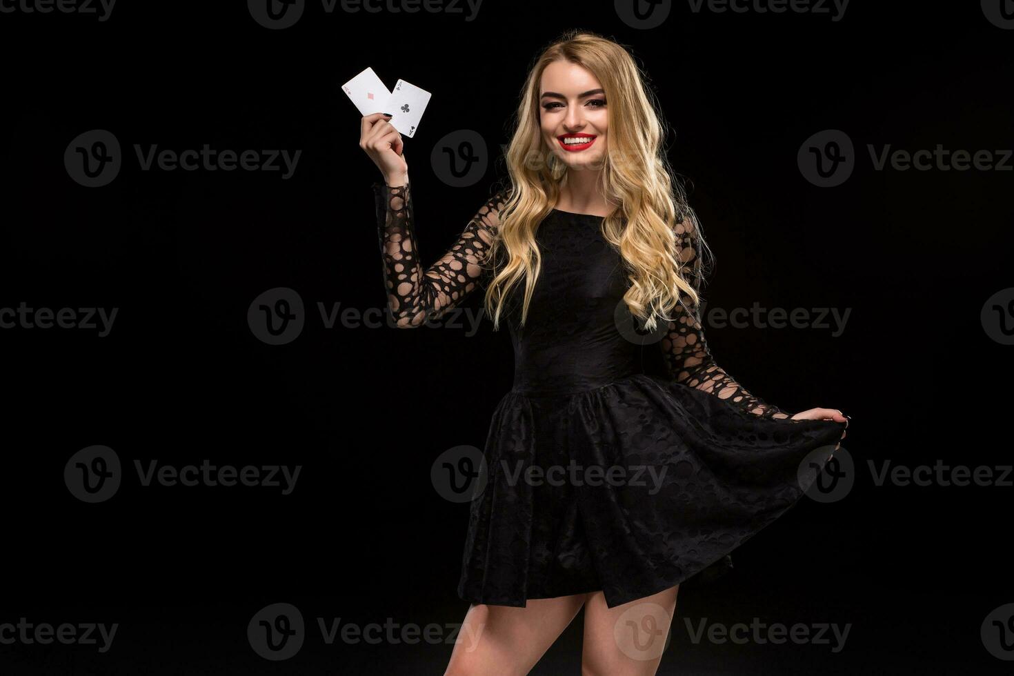 Beautiful young woman holding two ace of cards in her hand isolated on black background photo