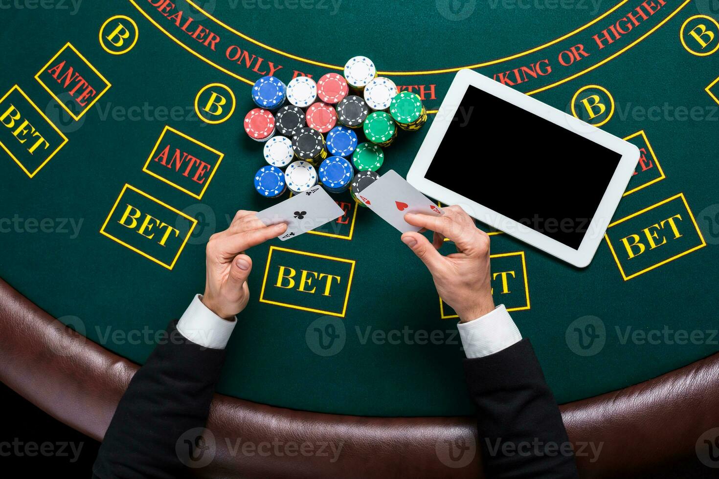 casino, online gambling, technology and people concept - close up of poker player with playing cards photo