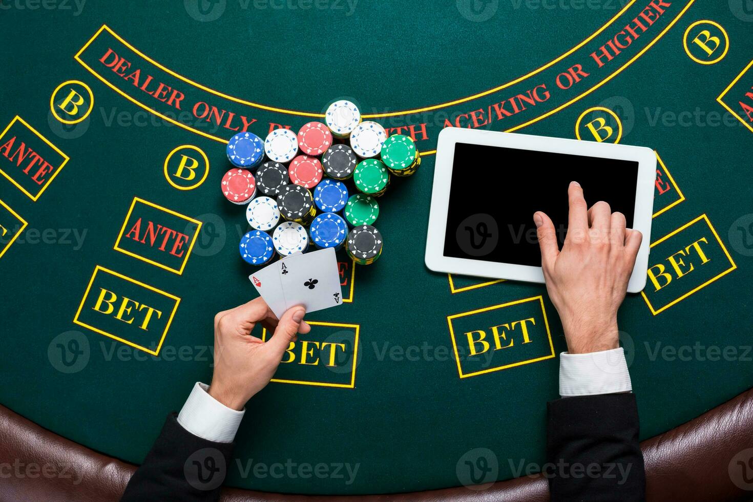casino, online gambling, technology and people concept - close up of poker player with playing cards photo