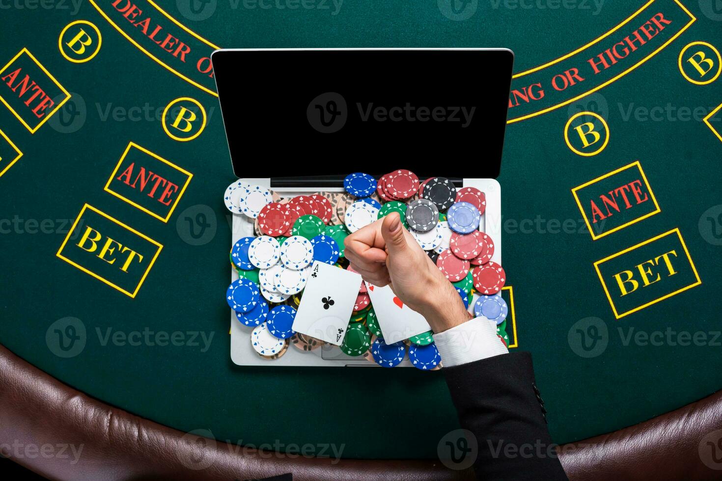 casino, online gambling, technology and people concept - close up of poker player with playing cards photo