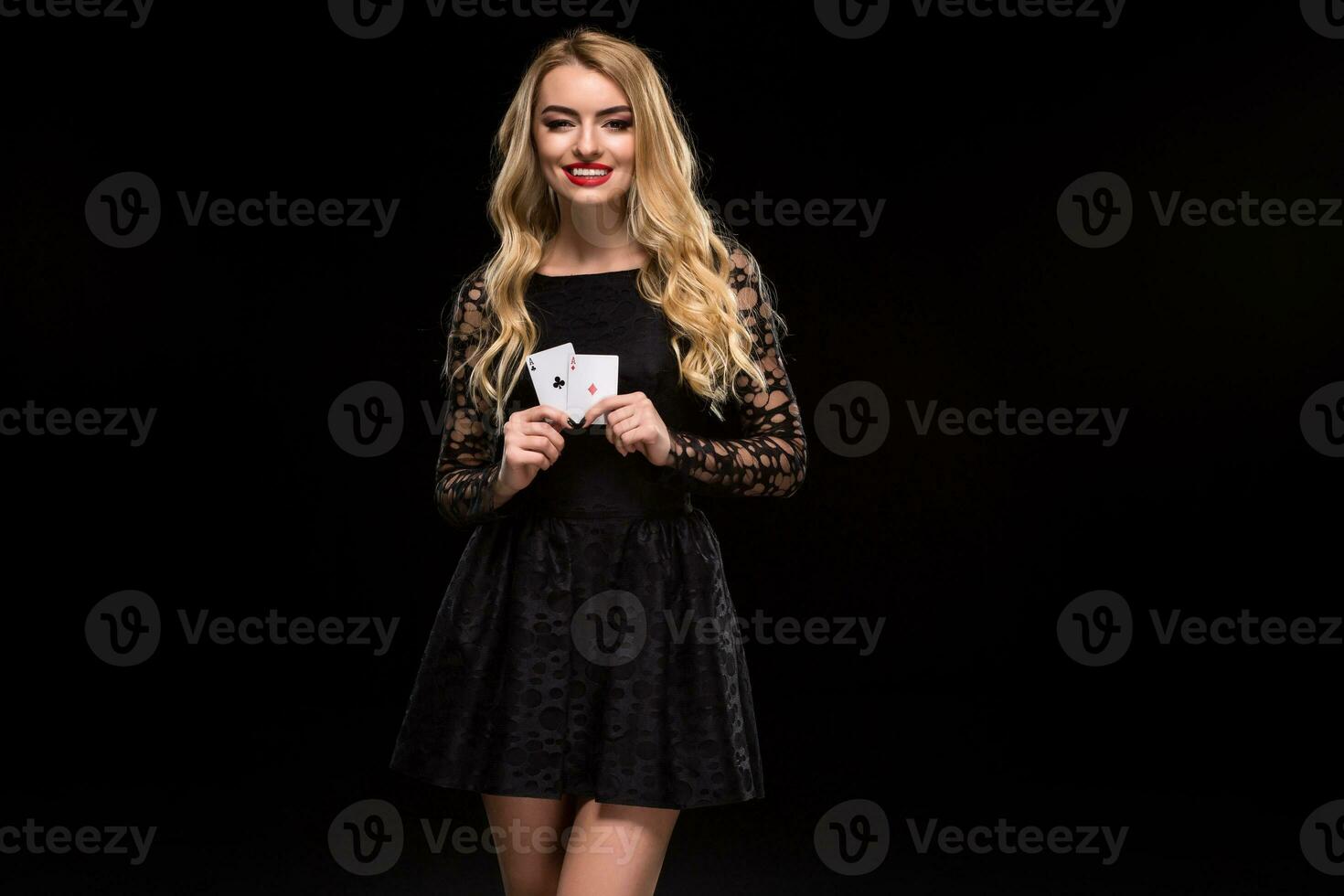 Beautiful young woman holding two ace of cards in her hand isolated on black background photo