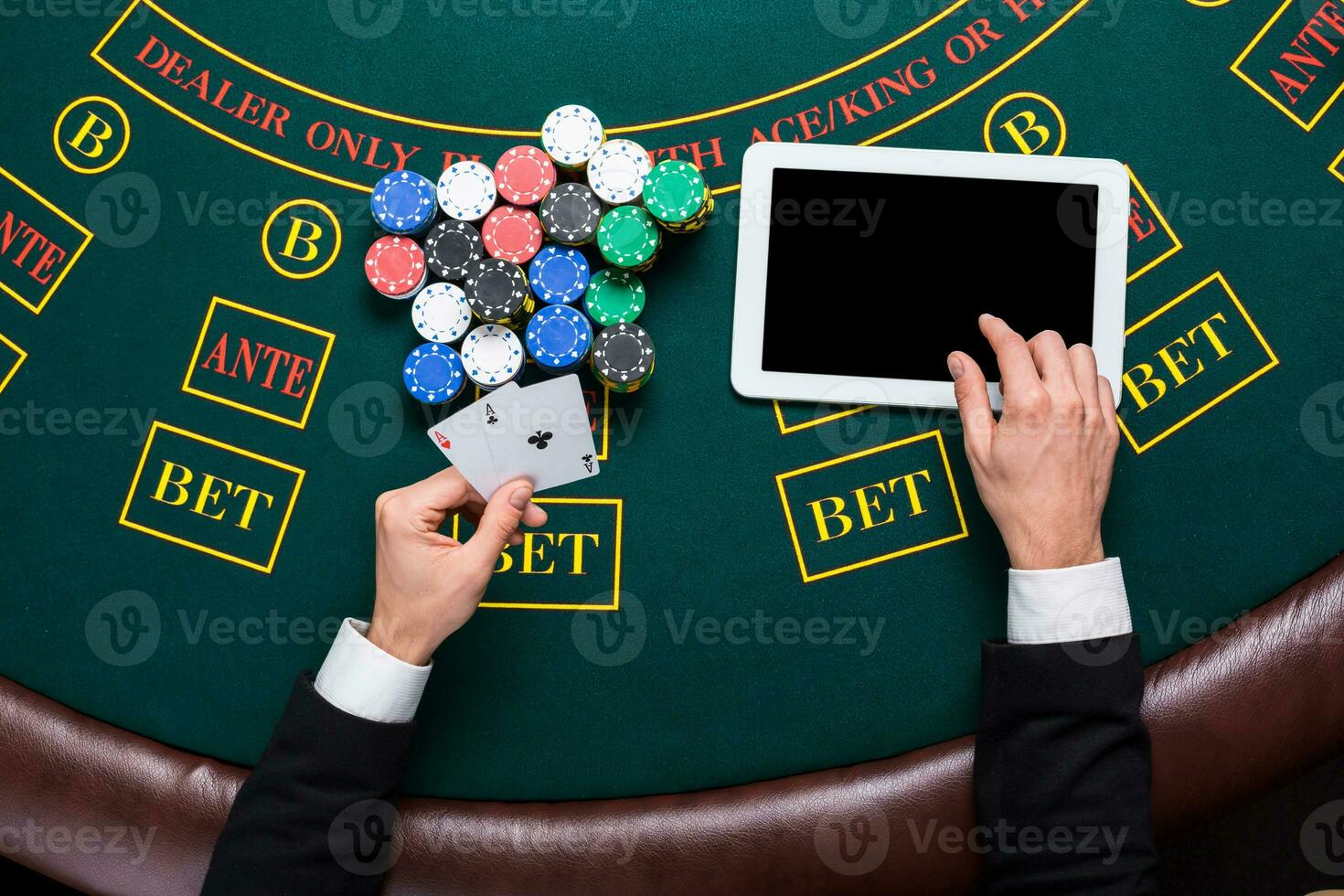 casino, online gambling, technology and people concept - close up of poker player with playing cards photo