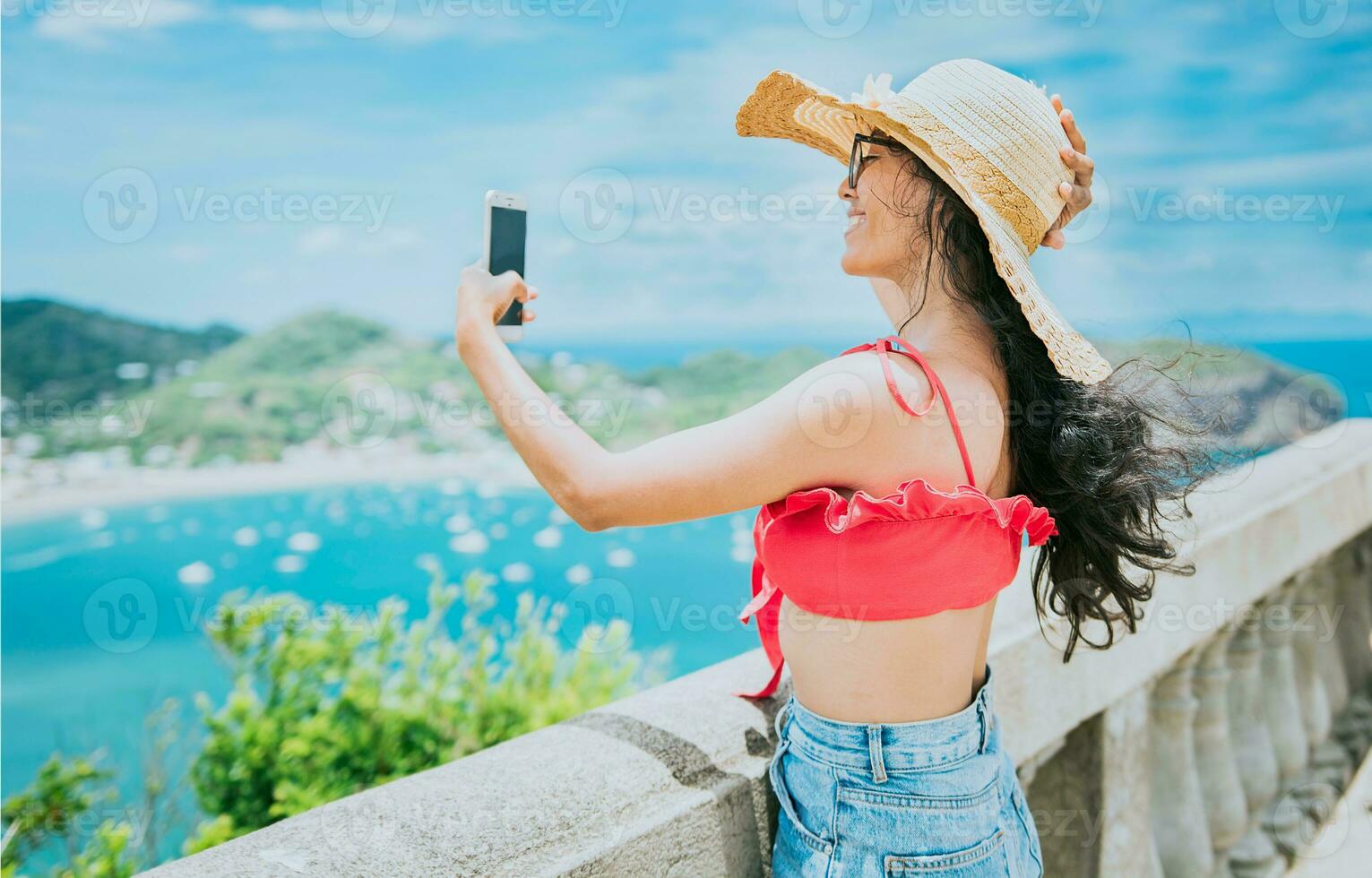 Happy tourist girl taking a selfie at a beach viewpoint. Beautiful tourist girl taking a selfie at the viewpoint of San Juan del Sur photo