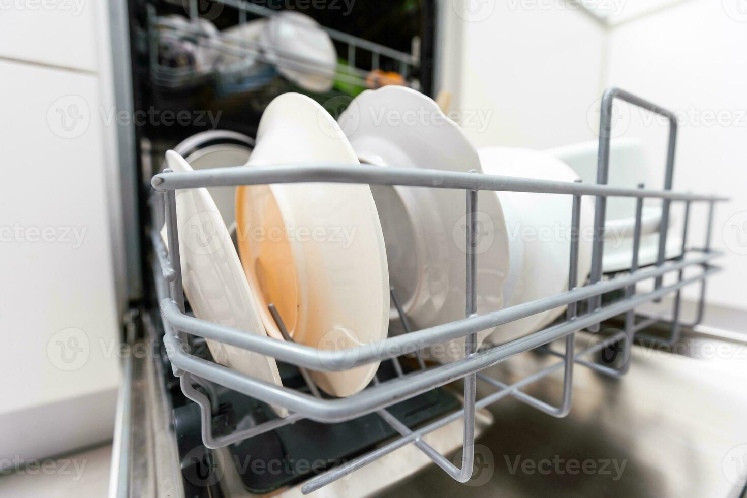 Dishes and cutlery on dishwashing machine. Clean dishes. photo