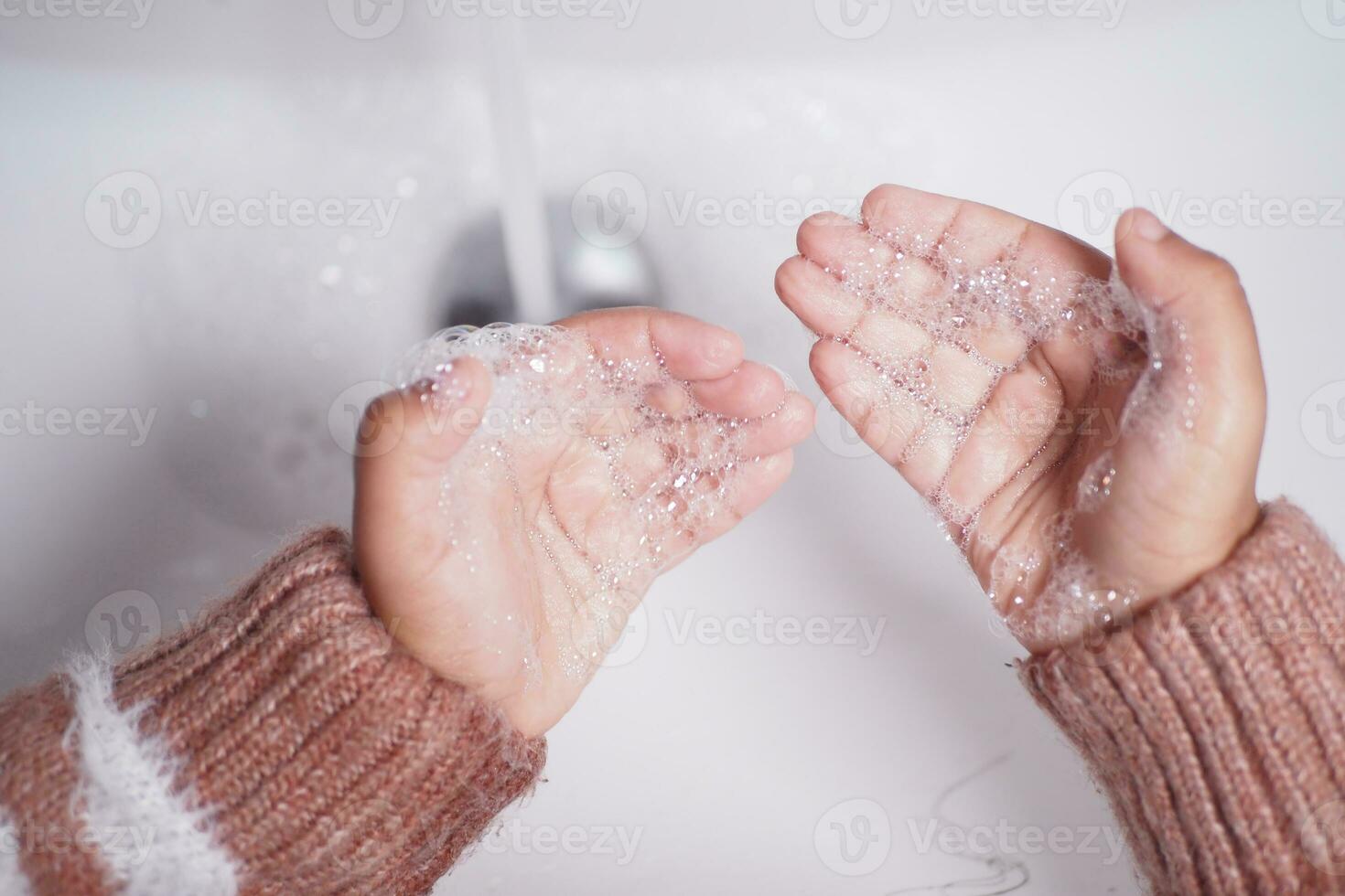 child washing hands with soap photo