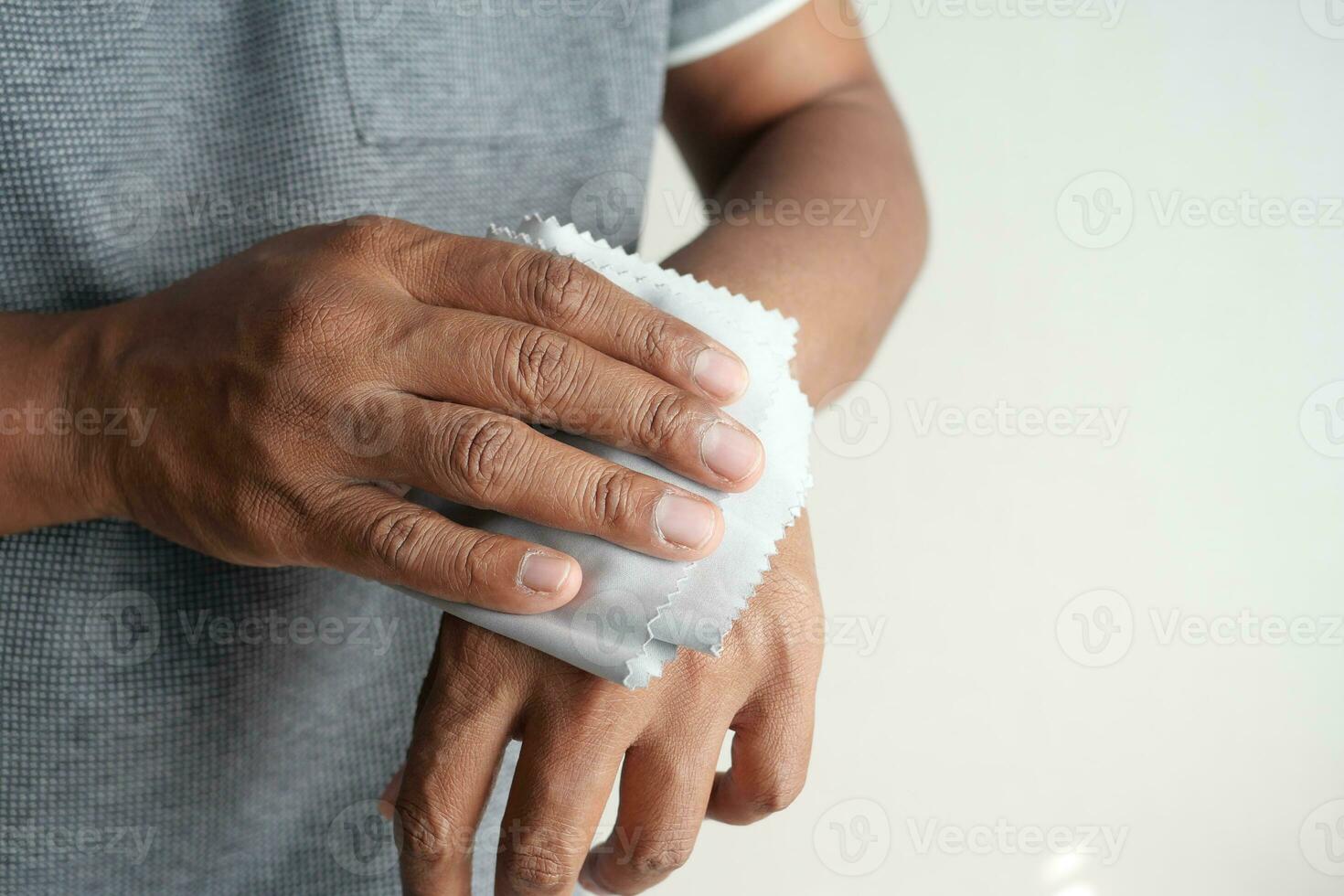 man disinfecting his hands with a wet wipe. photo