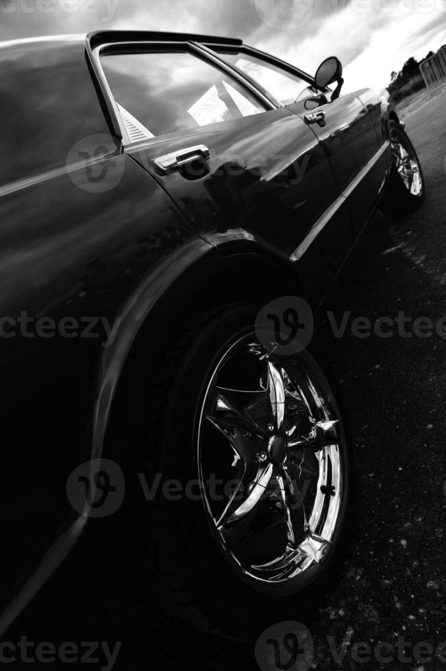 black and white photograph of a car parked on the street photo