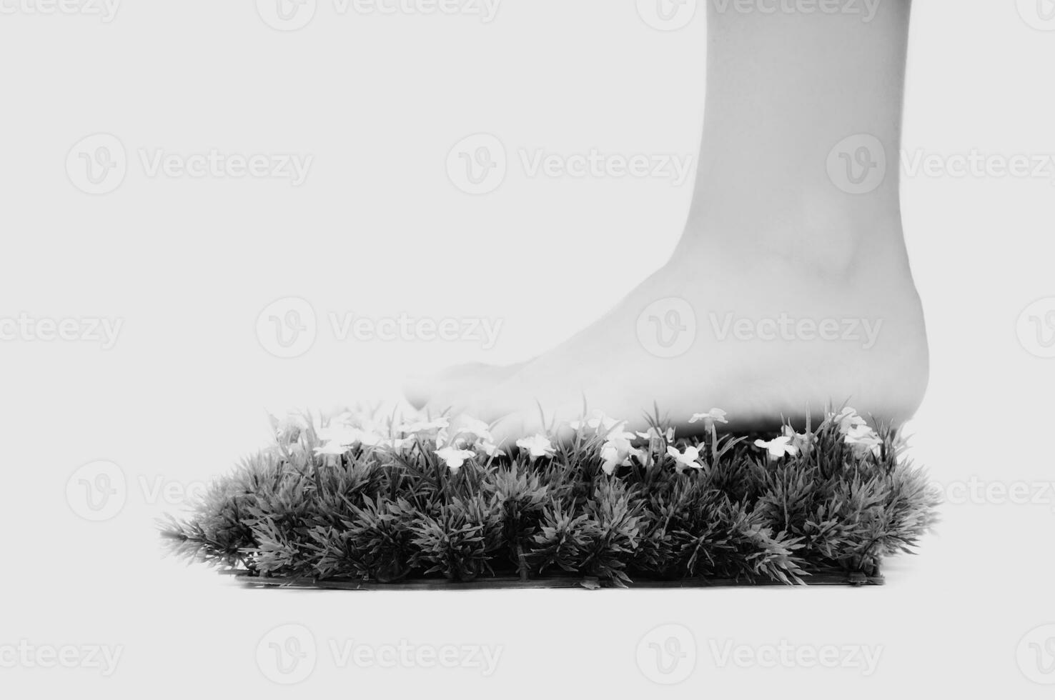 a person's foot is standing on a grassy surface photo