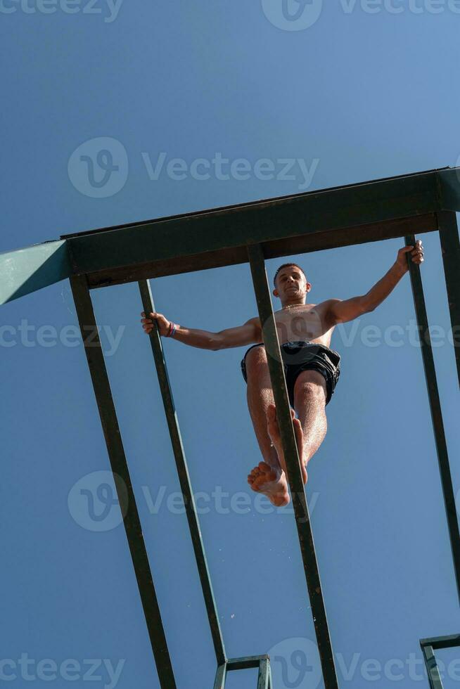 a man is jumping off of a bar photo