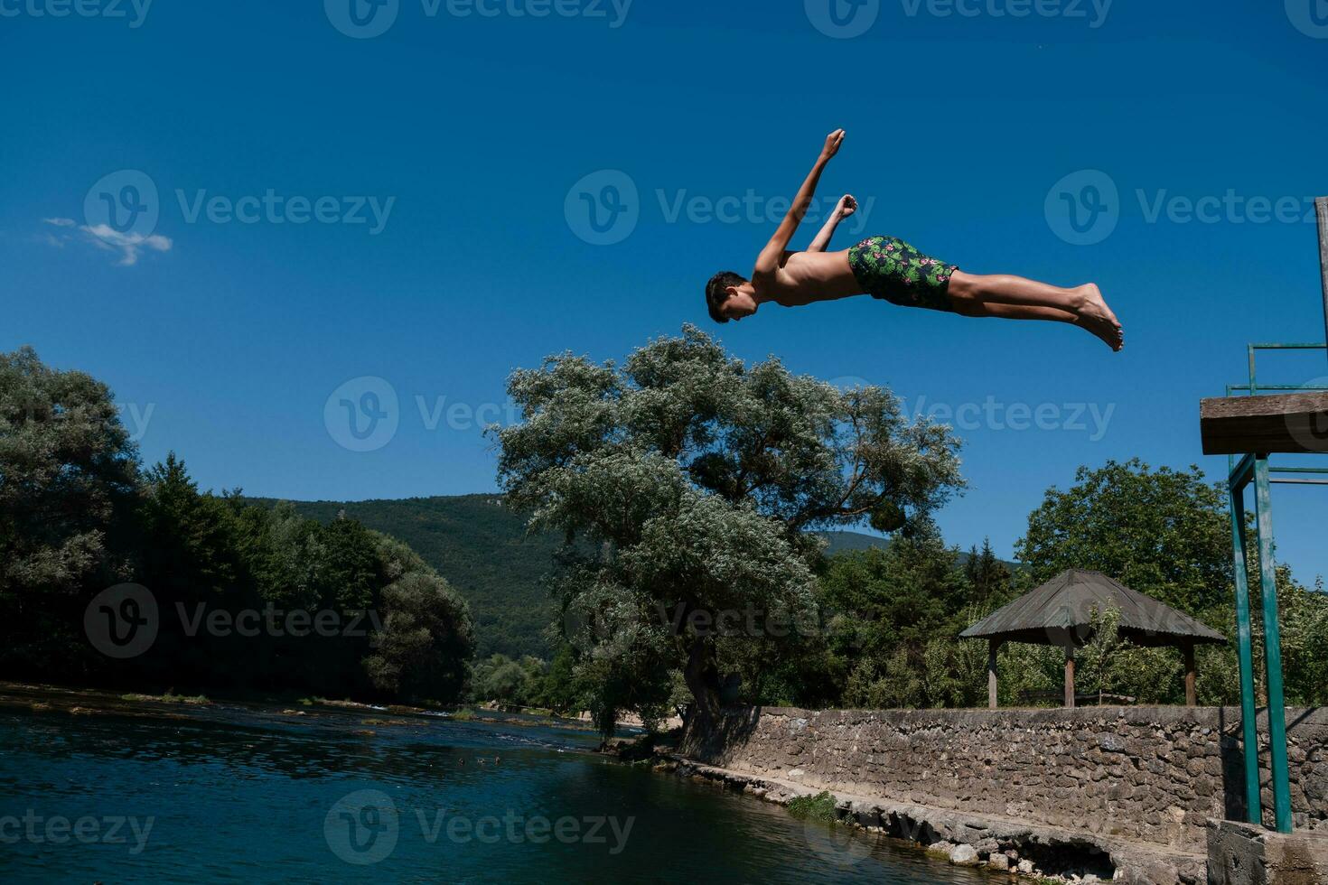a man in a swimsuit is jumping into the water photo