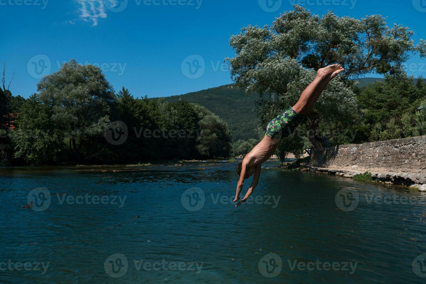 a man in a swimsuit is jumping into the water photo