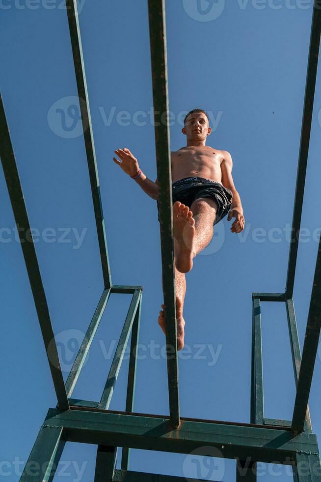 a man is jumping off of a bar photo