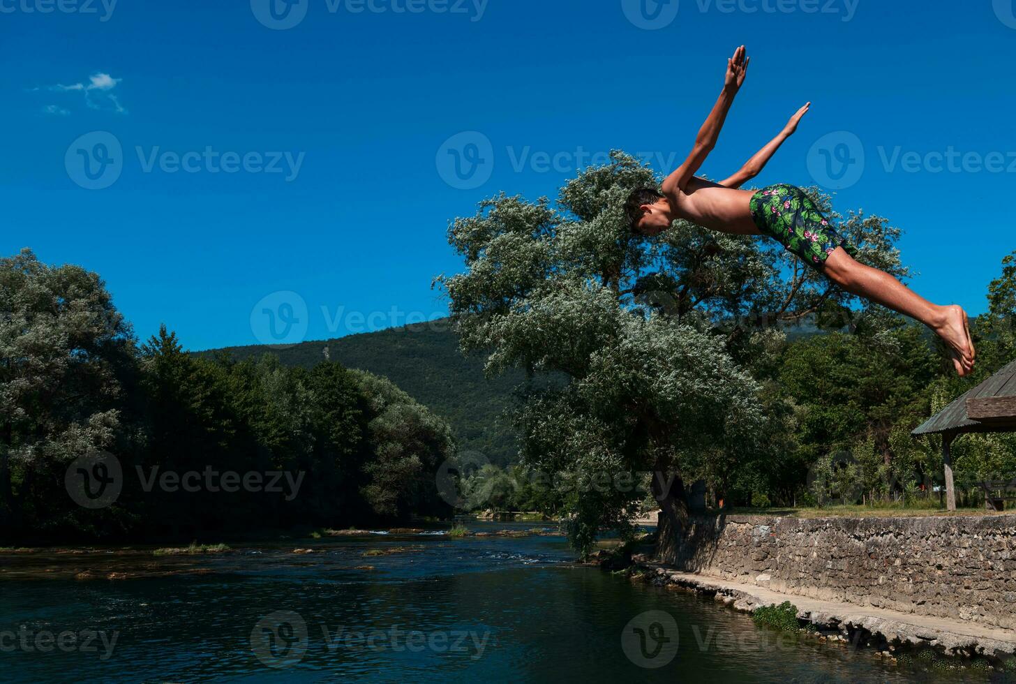 a man in a swimsuit is jumping into the water photo