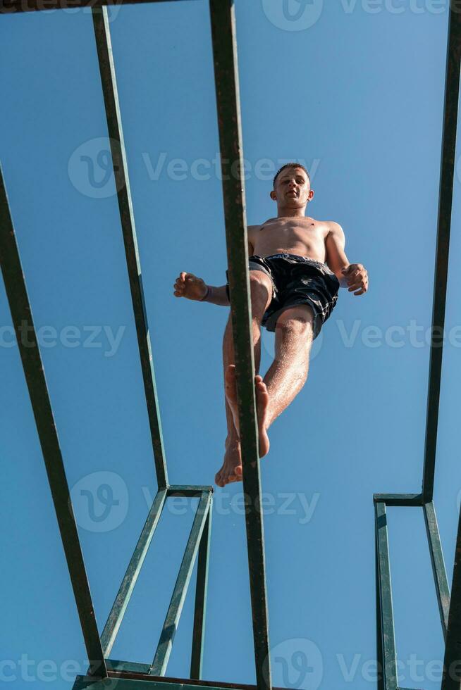 a man is jumping off of a bar photo
