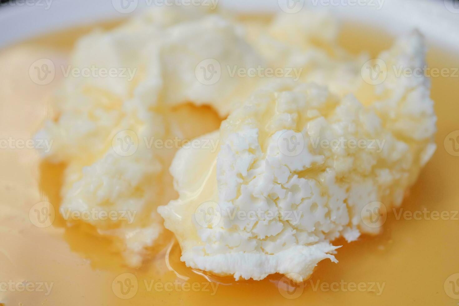 butter cream and honey in a bowl on table . photo
