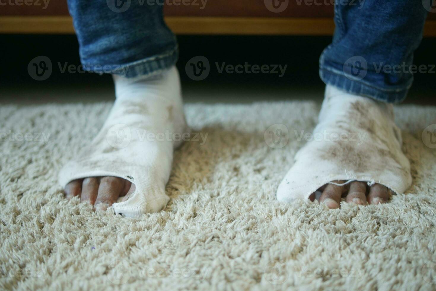 men feet with dirty socks while sitting on sofa photo