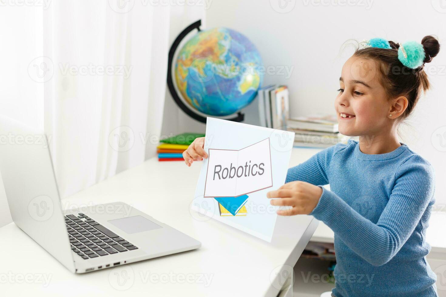 little girl studying robotics on laptop online photo