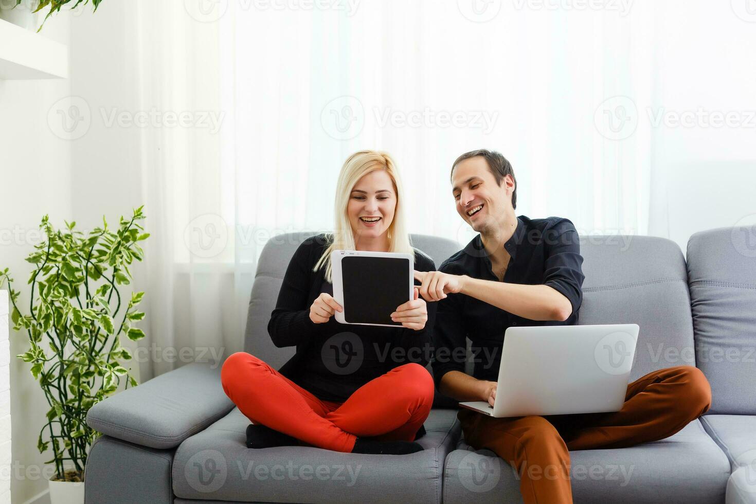 Cheerful couple searching something on laptop at home photo