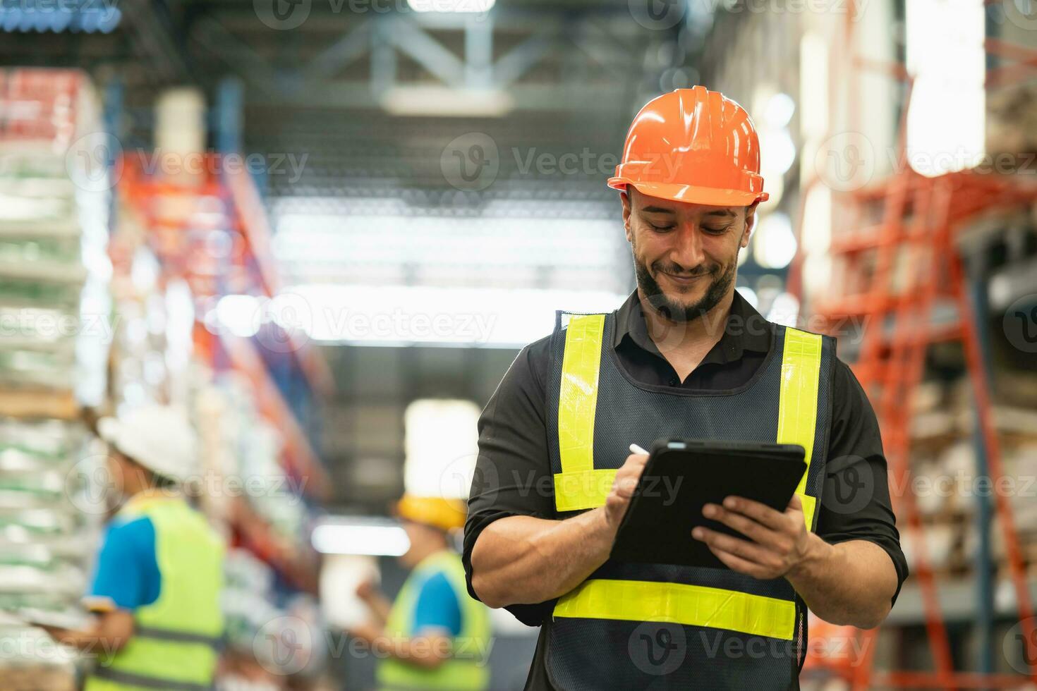 Professional manager man employee smile using tablet check stock working at warehouse. Worker wearing high visibility clothing and a hard hat, helmet and checking and count up goods boxes delivery. photo