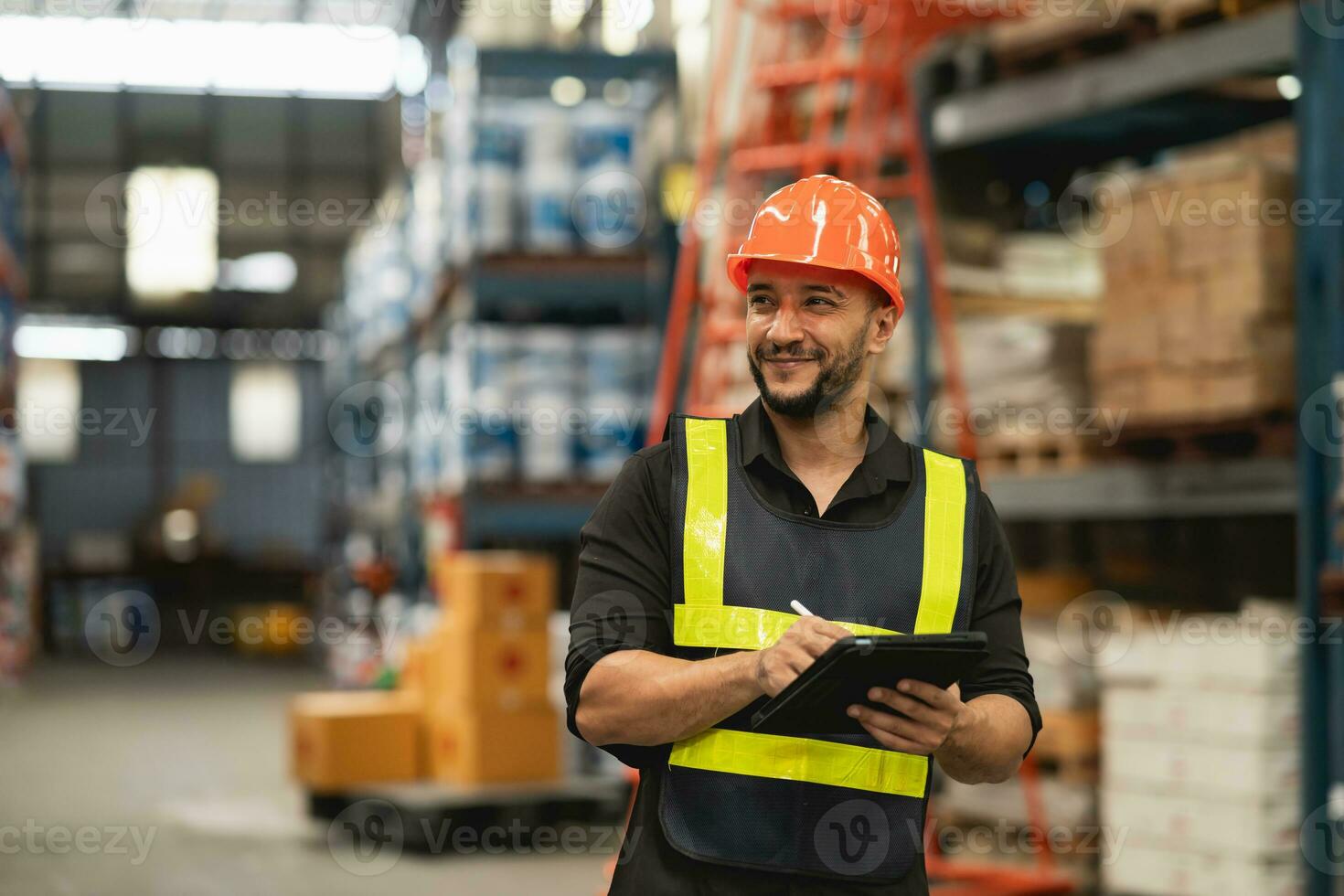 Professional manager man employee smile using tablet check stock working at warehouse. Worker wearing high visibility clothing and a hard hat, helmet and checking and count up goods boxes delivery. photo