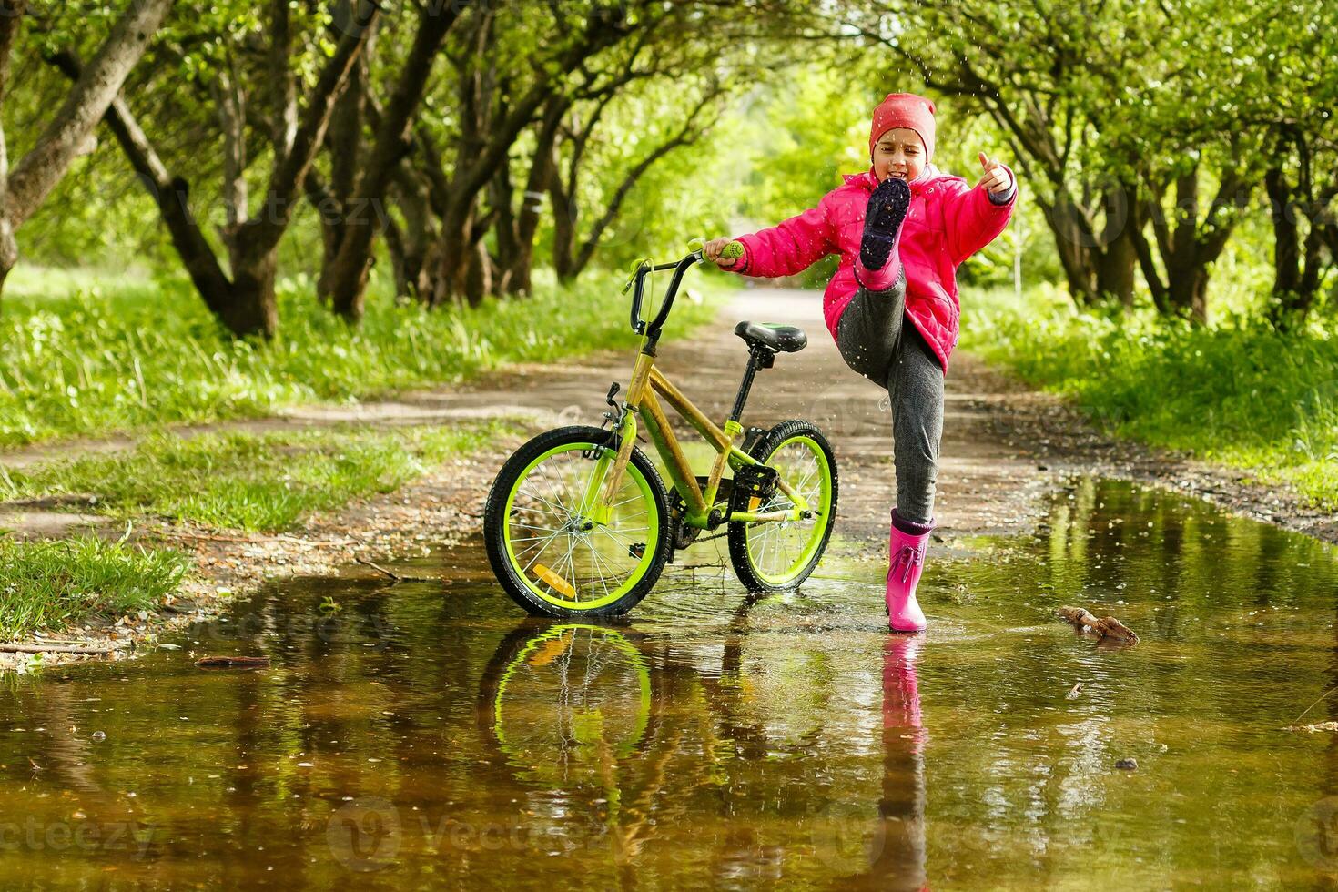 little girl riding bike in water puddle photo