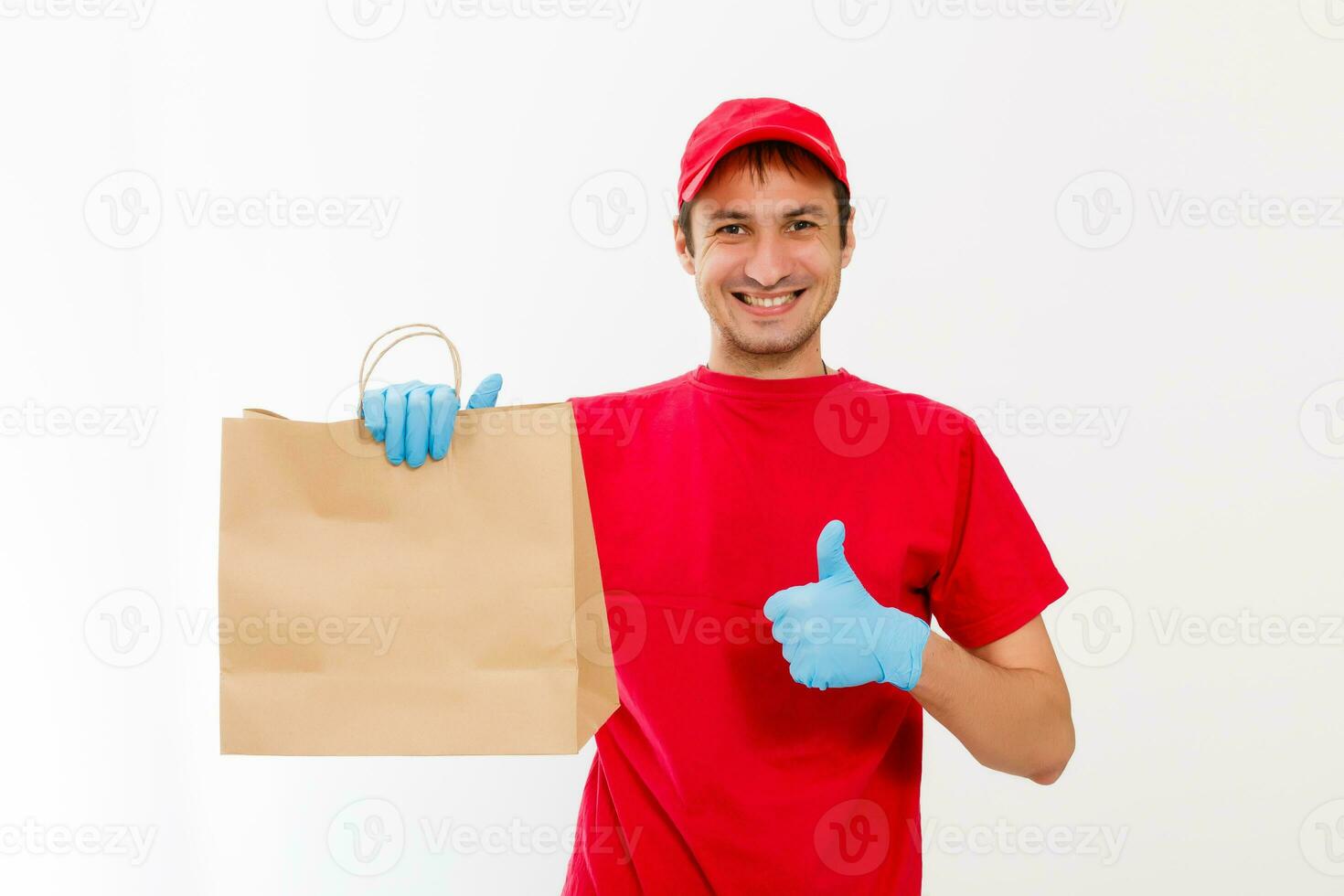Smiling young delivery man holding and carrying a cardbox isolated on white background photo