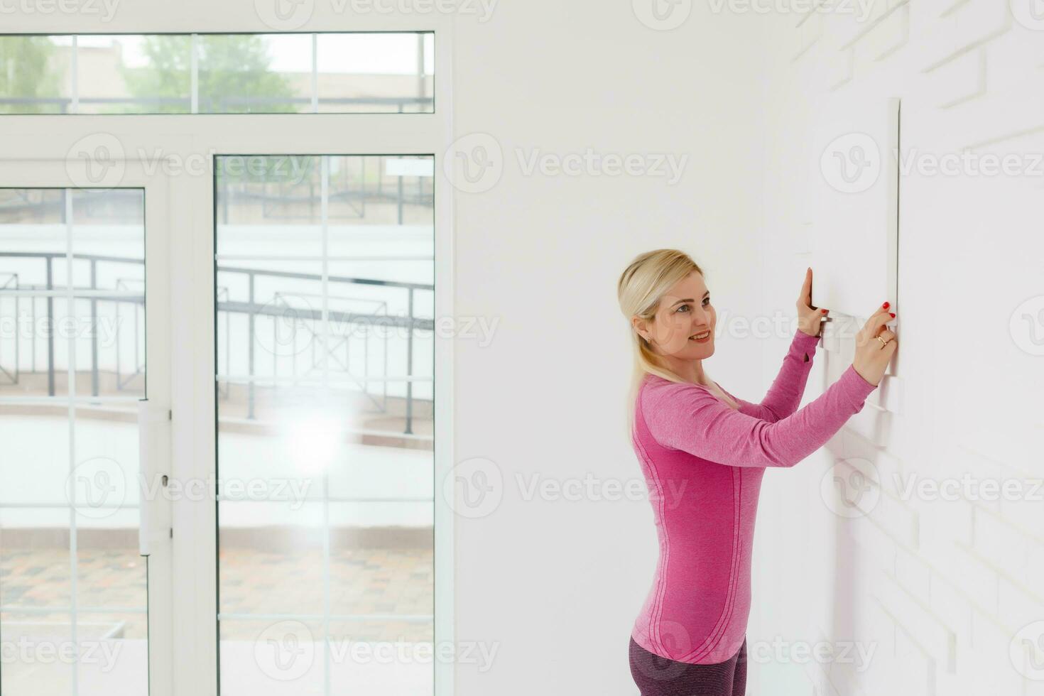Photo of woman looking at the blank white canvas. Horizontal, mockup