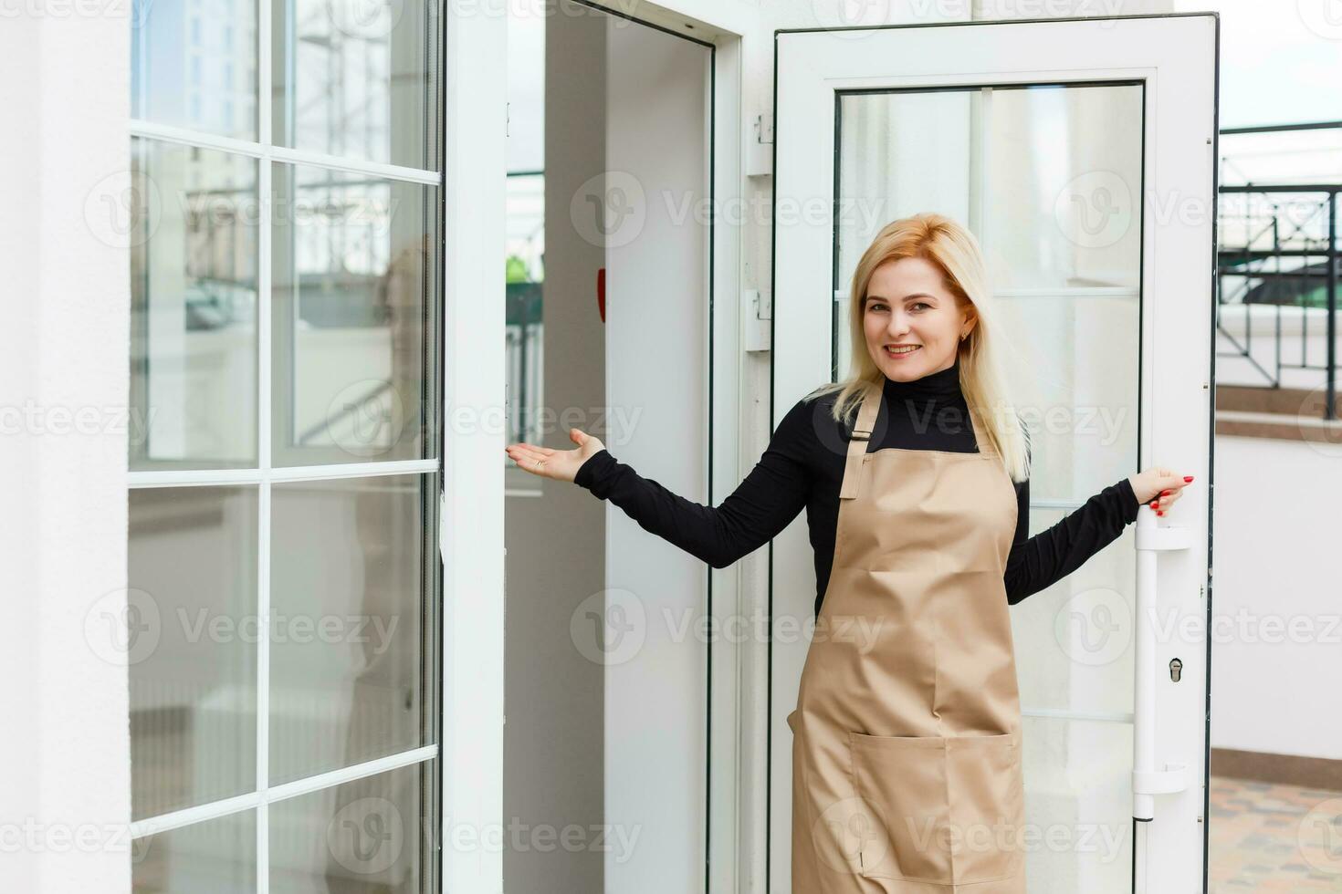 Half length portrait of waitress dressed in apron with copy space for brand name open store starting work ready to serve visitors, woman entrepreneur barista standing at restaurant entrance photo