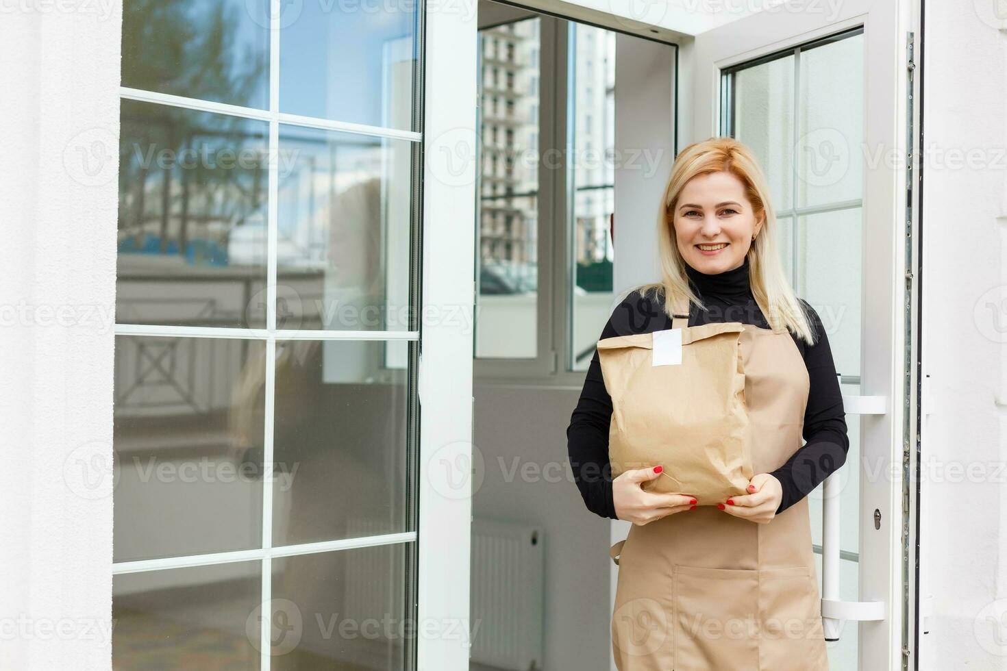 Half length portrait of waitress dressed in apron with copy space for brand name open store starting work ready to serve visitors, woman entrepreneur barista standing at restaurant entrance photo