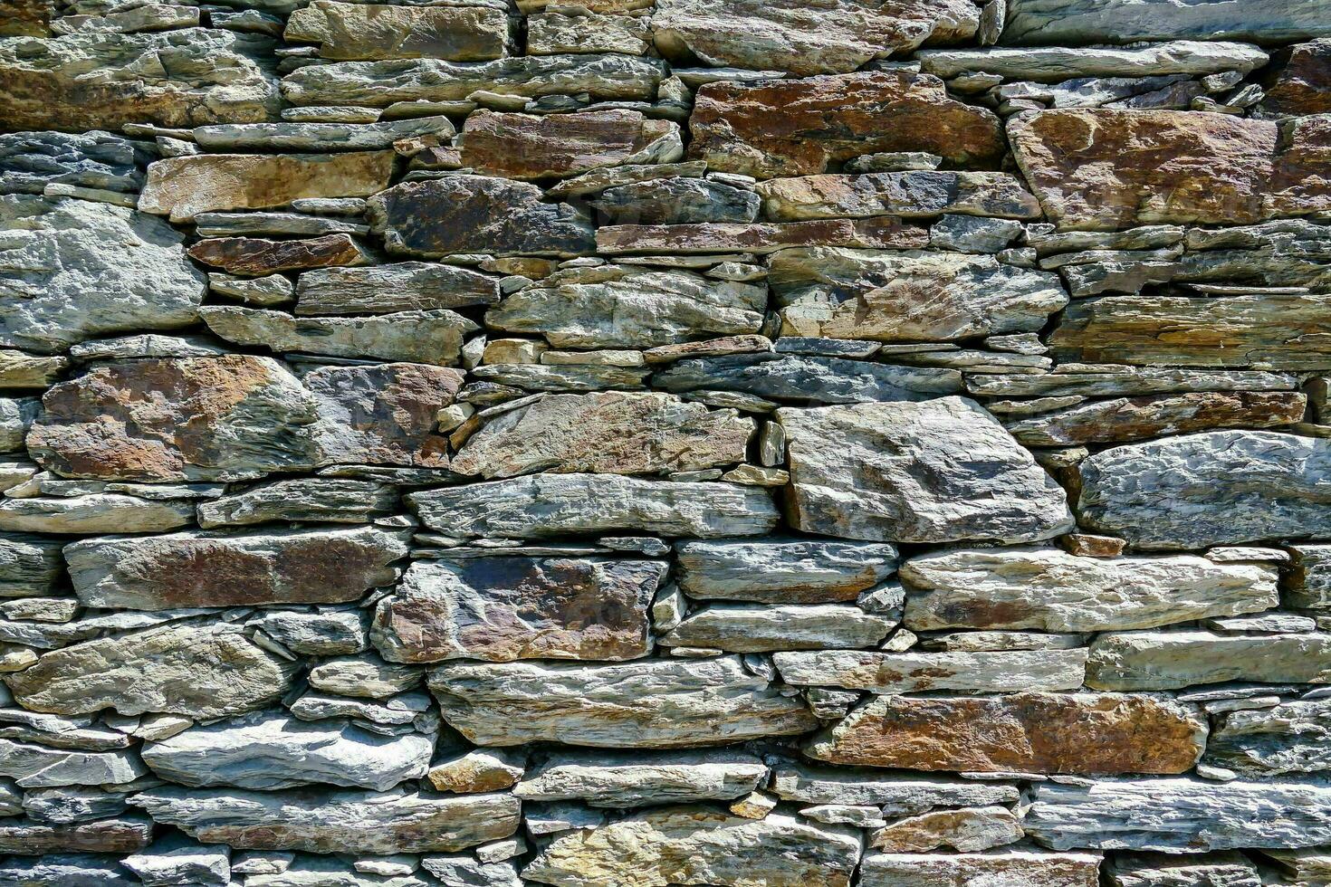 a stone wall with many different types of rocks photo