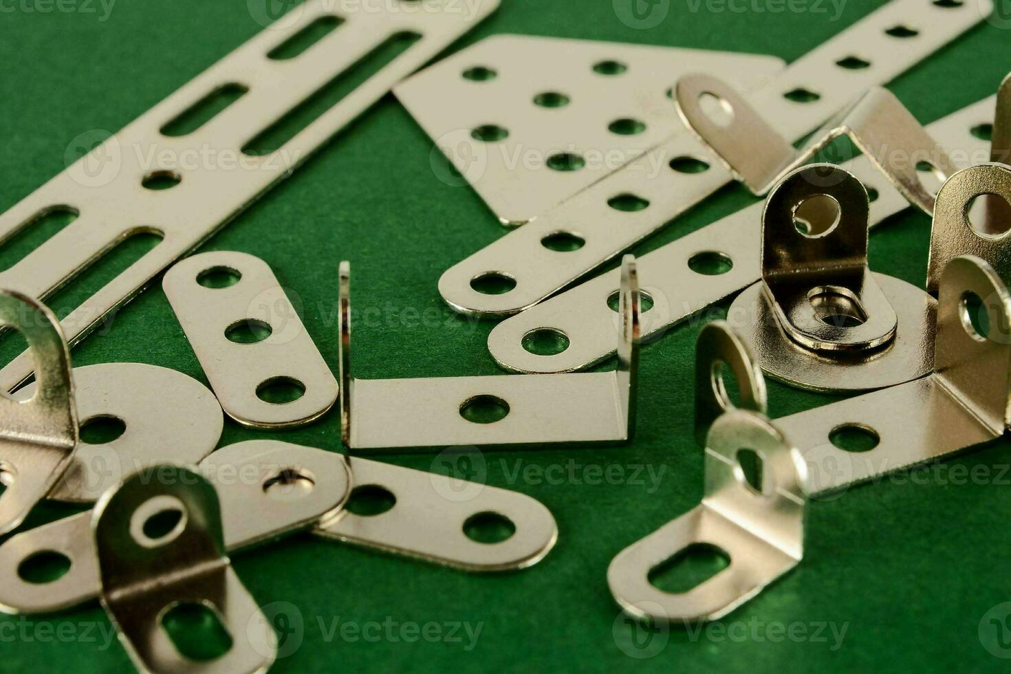 a group of metal clips and screws on a green surface photo