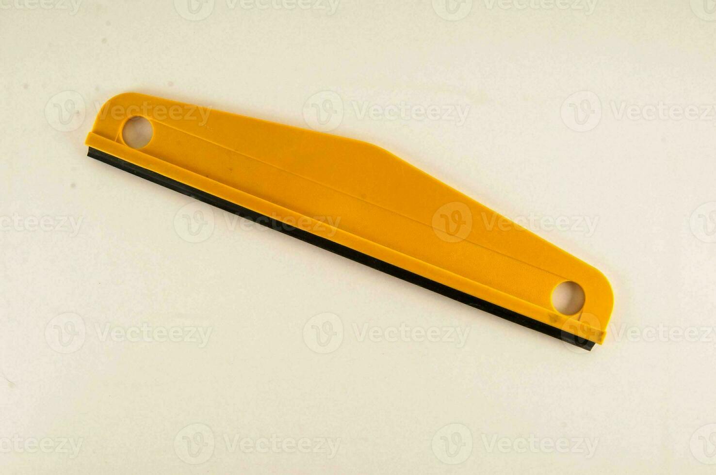 a yellow plastic tool with black handles photo
