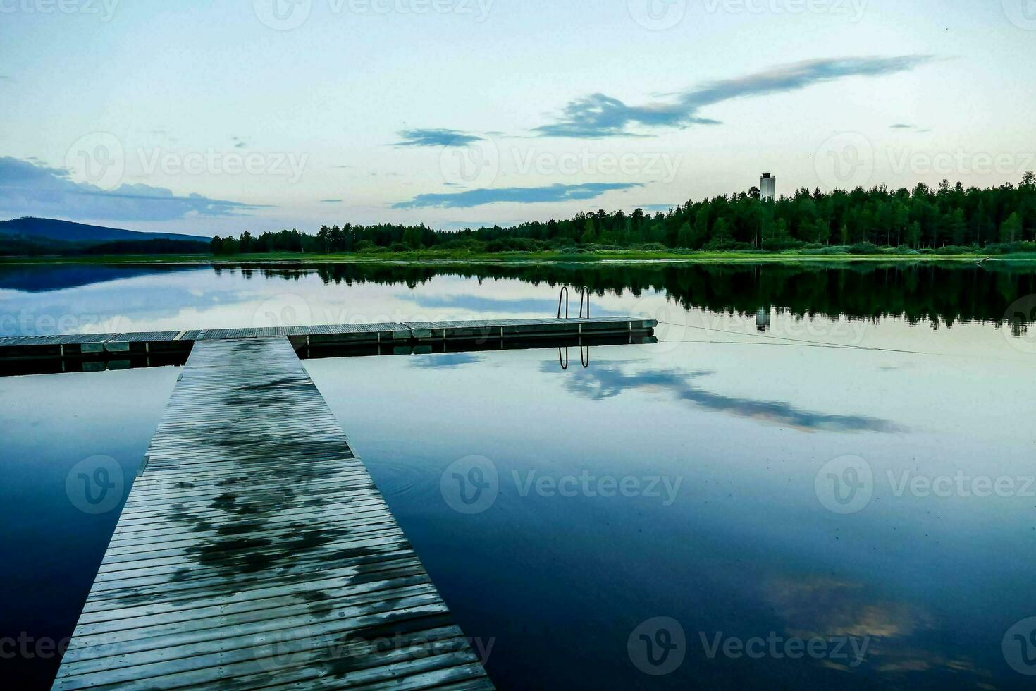 a dock on a lake with a mountain in the background photo