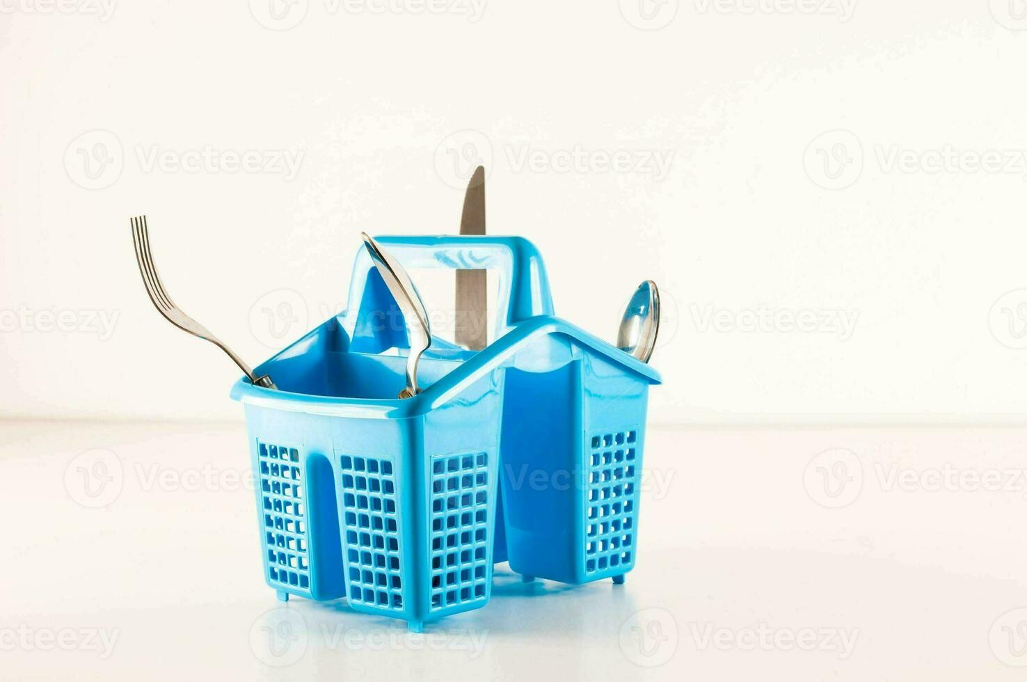 a blue plastic basket with four forks and knives photo