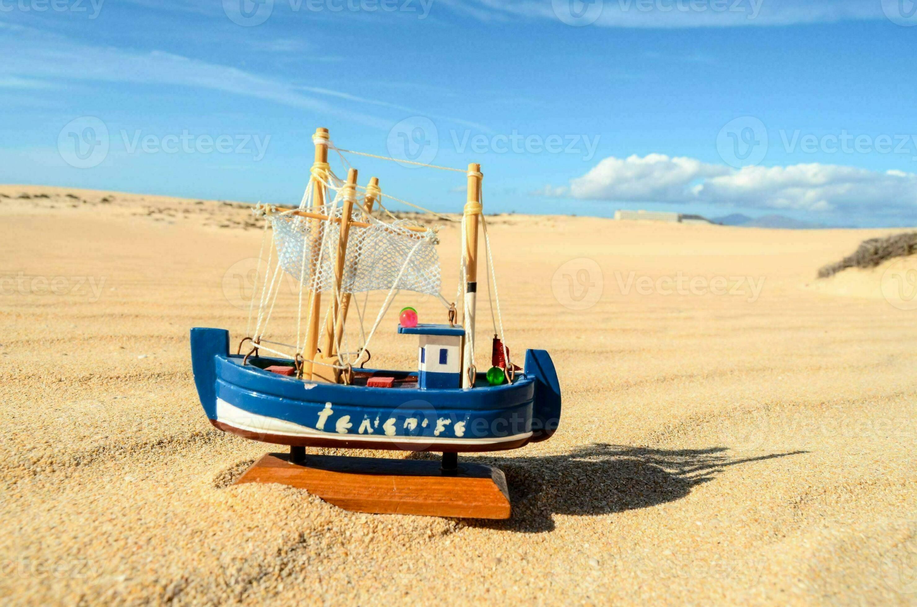 a toy boat on the sand in the desert 35193082 Stock Photo at Vecteezy