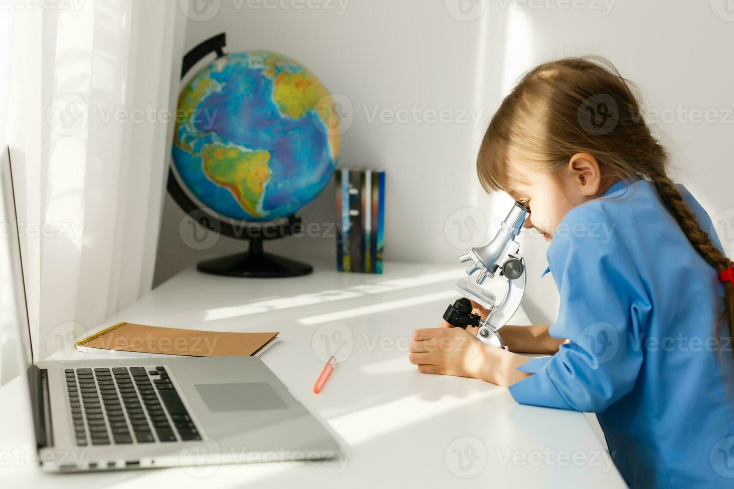 Remote lessons. The child smiles happily and gets knowledge remotely. Little girl study online learning from home. Online school. photo