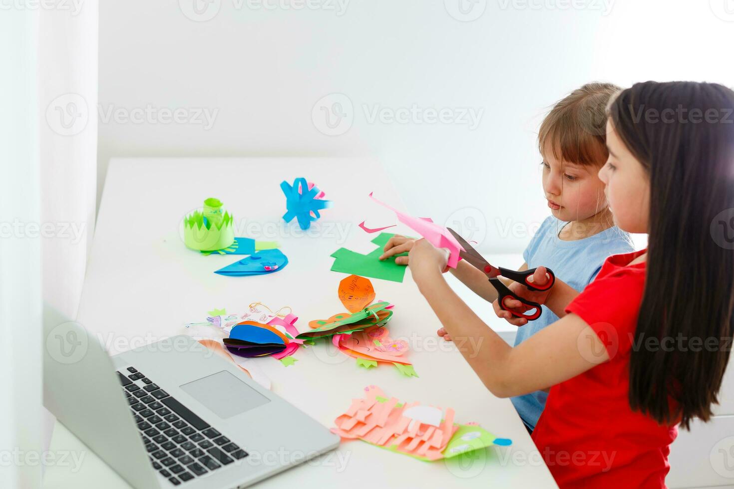 Cool online school. Kids studying online at home using a laptop. Cheerful young little girls using laptop computer studying through online e-learning system. Distance or remote learning photo