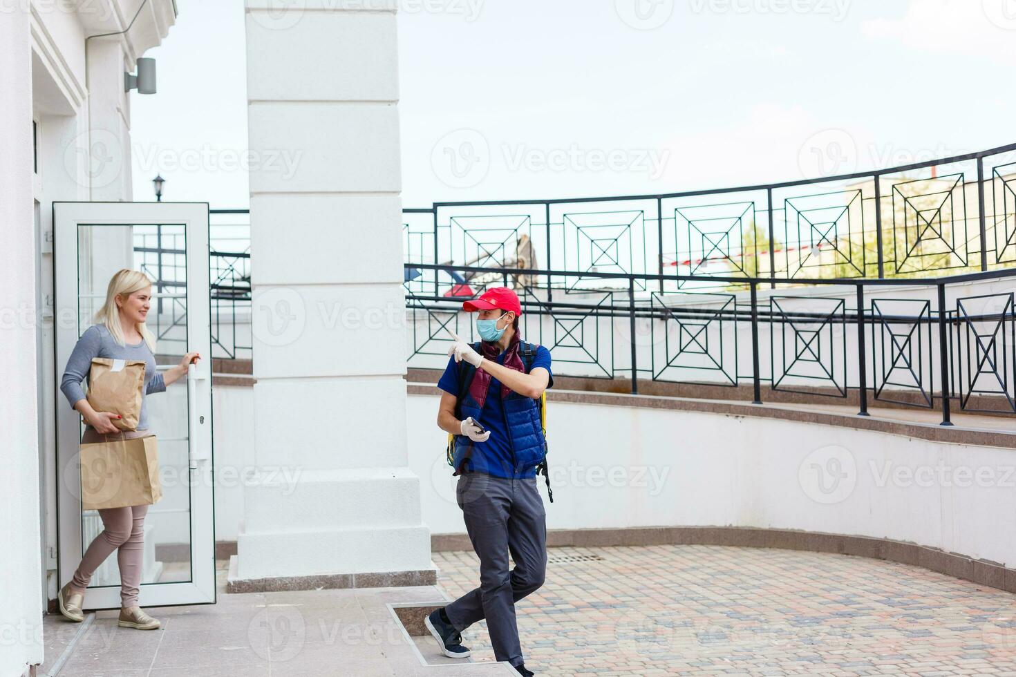 entrega hombre con termo mochila y sonriente mujer en oficina foto