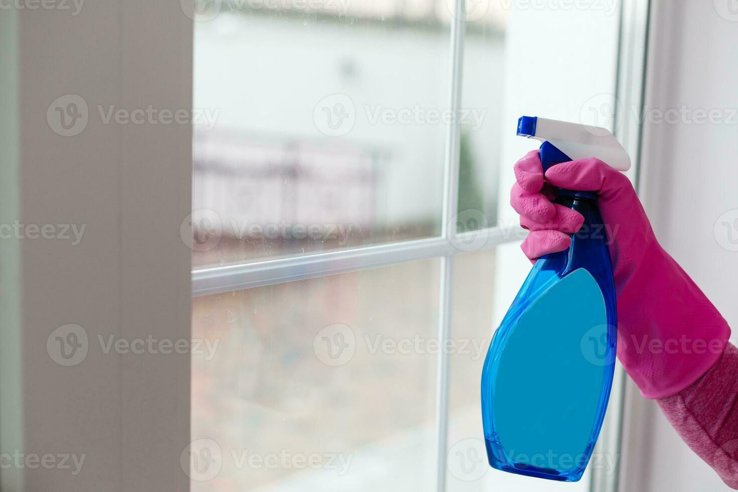 Woman cleaning a window with yellow cloth photo