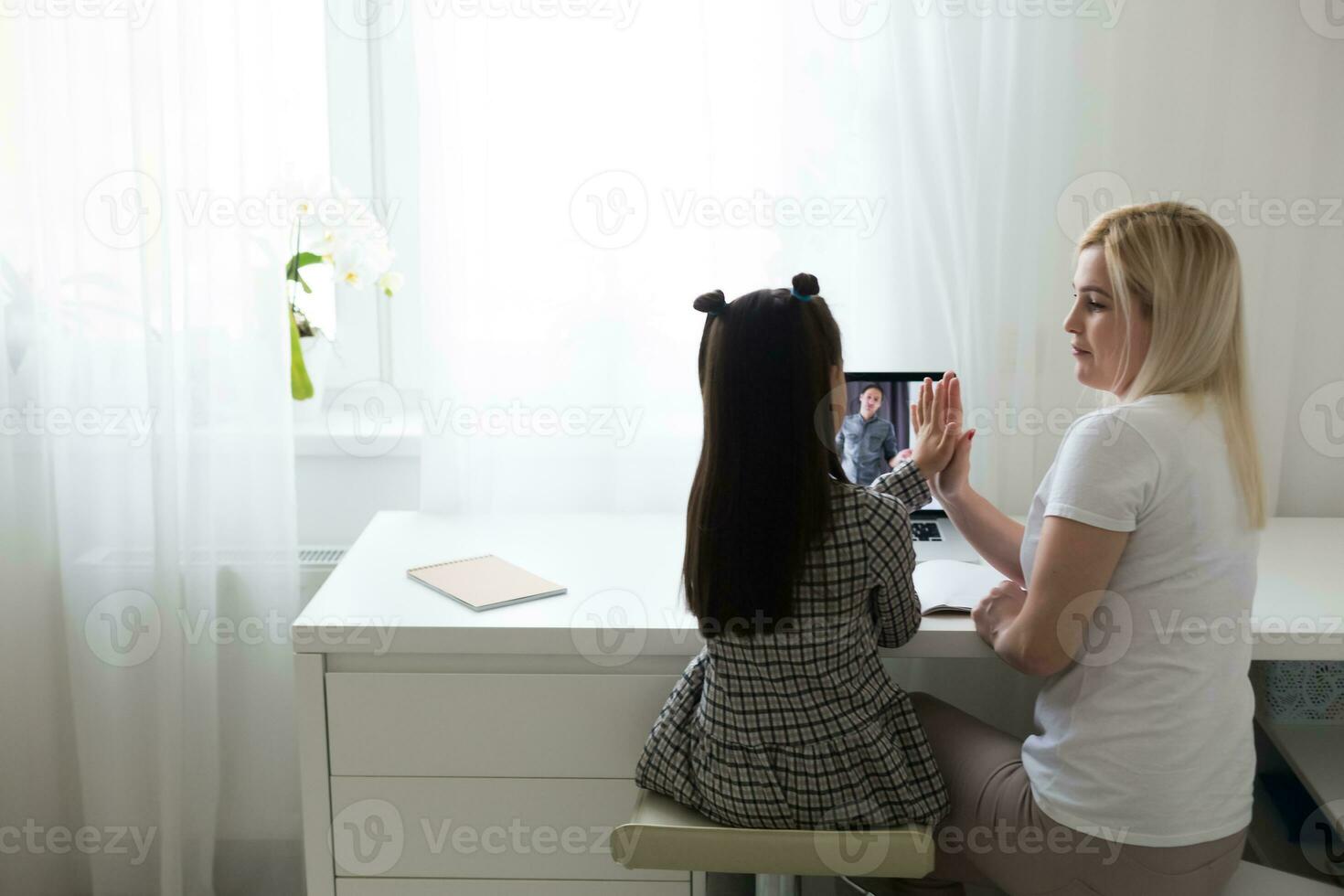 trabajando desde hogar con niño. contento hija abrazando madre. joven mujer y linda niño utilizando ordenador portátil. persona de libre dedicación lugar de trabajo. hembra negocio, distancia aprendiendo. estilo de vida familia momento. foto