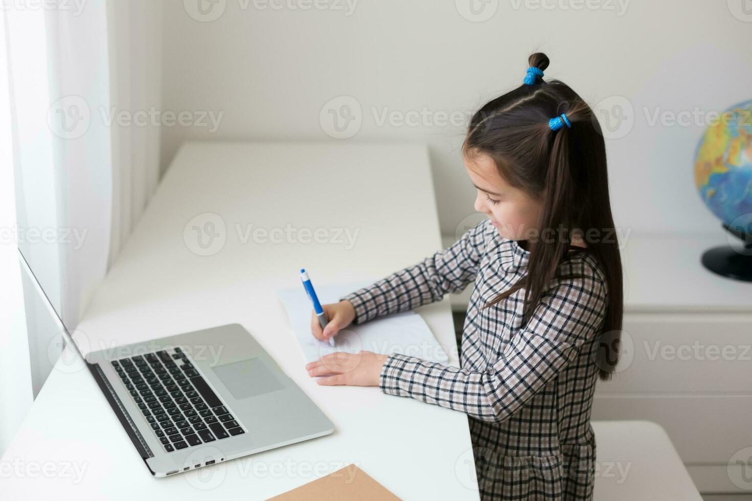 cheerfully cute girl children excited using computer learning schoolwork. kid enjoy e-learning in holiday at home. photo