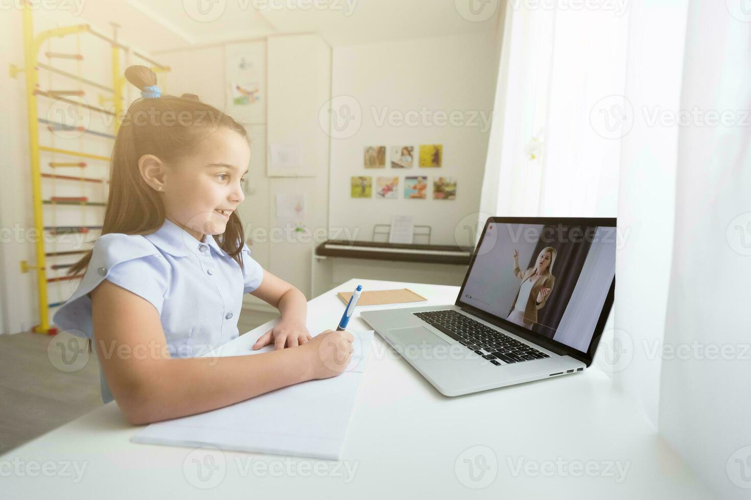 Pretty stylish schoolgirl studying homework math during her online lesson at home, social distance during quarantine, self-isolation, online education concept, home schooler photo